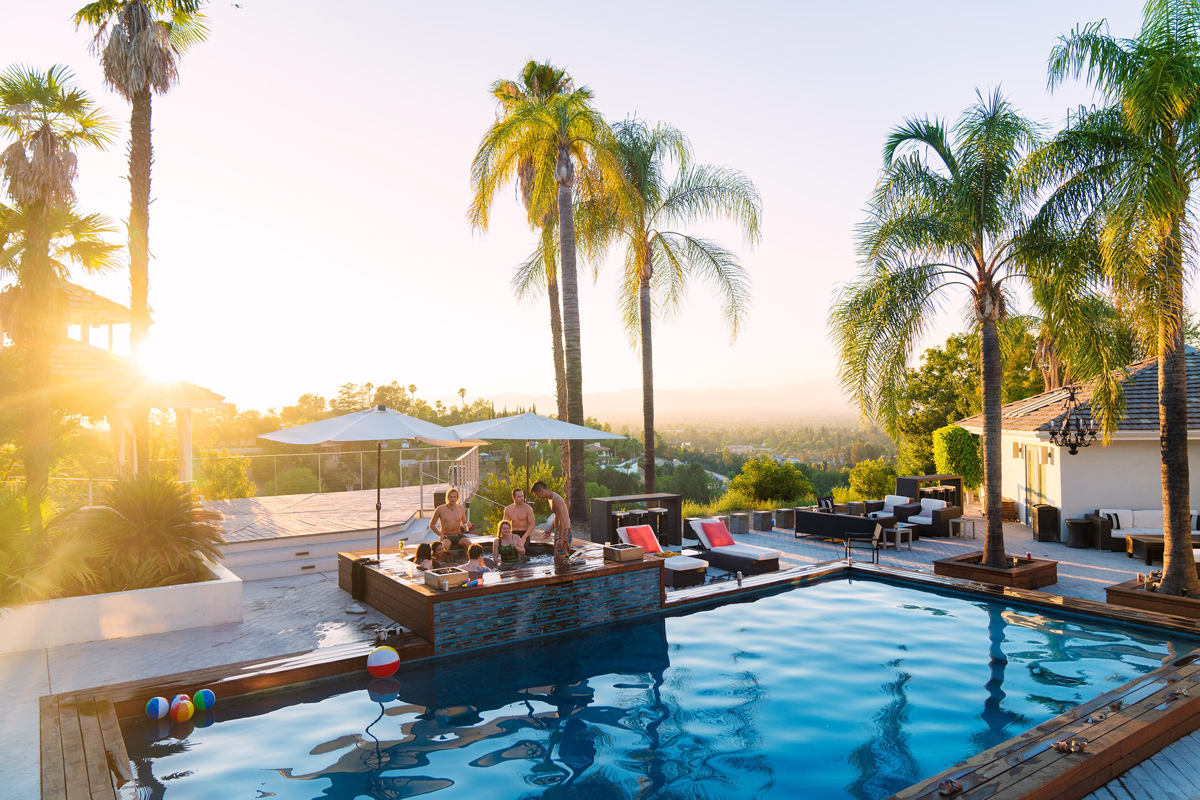 People partying in a hot tub at sunset